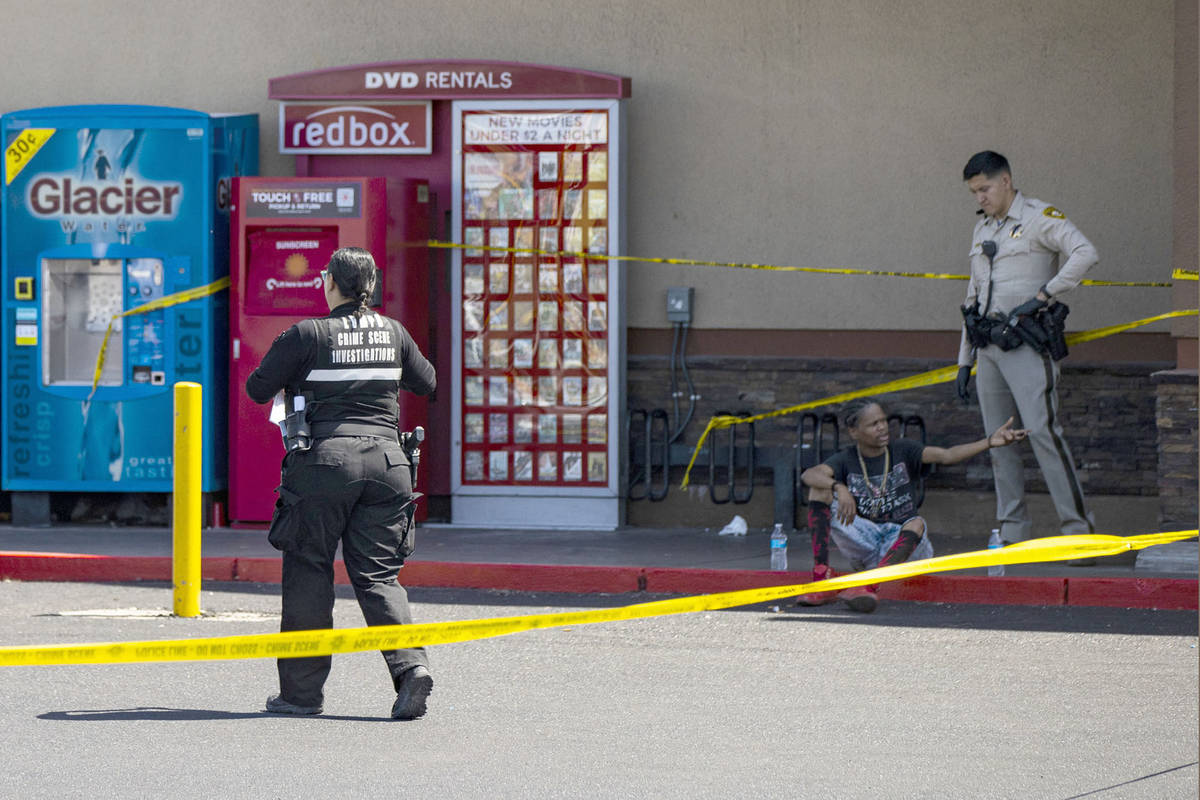 A man is detained as Las Vegas police investigate the scene of a shooting at Tropicana Avenue a ...