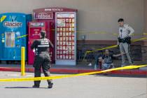 A man is detained as Las Vegas police investigate the scene of a shooting at Tropicana Avenue a ...