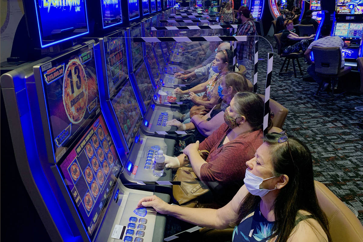 Plexiglass shields players as they gamble at Gila River Casino's Lone Butte location on the pac ...