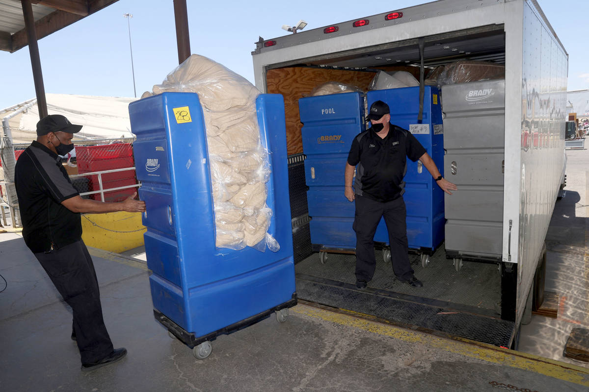 Aria workers Anthony Green, left, and Paul Gillespie load blankets, comforters and pillows dona ...