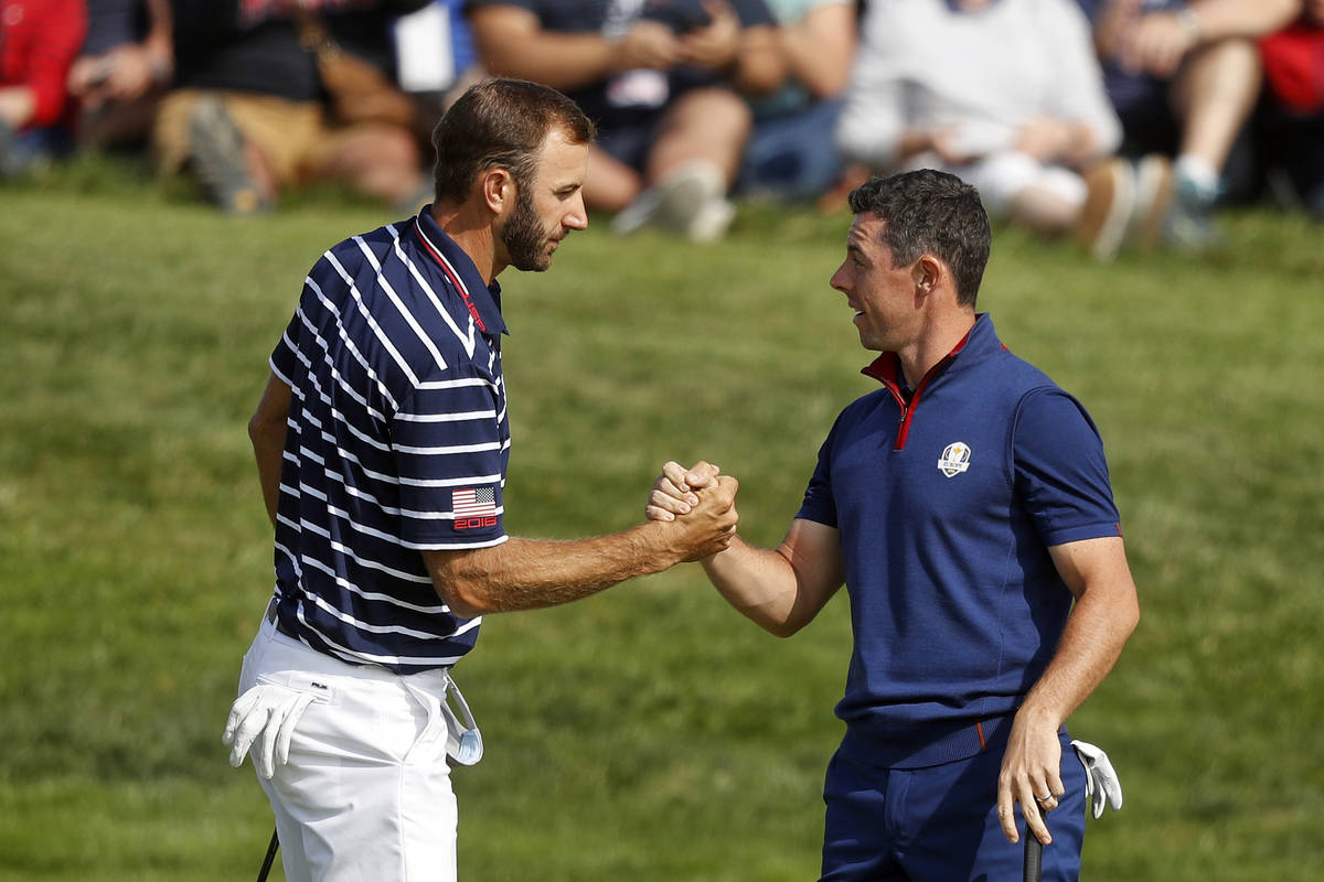 In this Sept. 28, 2018, file photo, Dustin Johnson left, and Rory McIlroy shake hands on 16th g ...