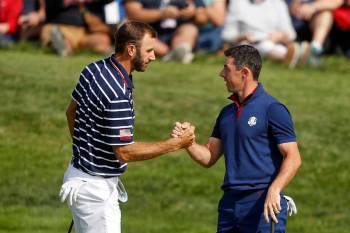 FILE - In this Sept. 28, 2018, file photo, Dustin Johnson left, and Rory McIlroy shake hands on ...
