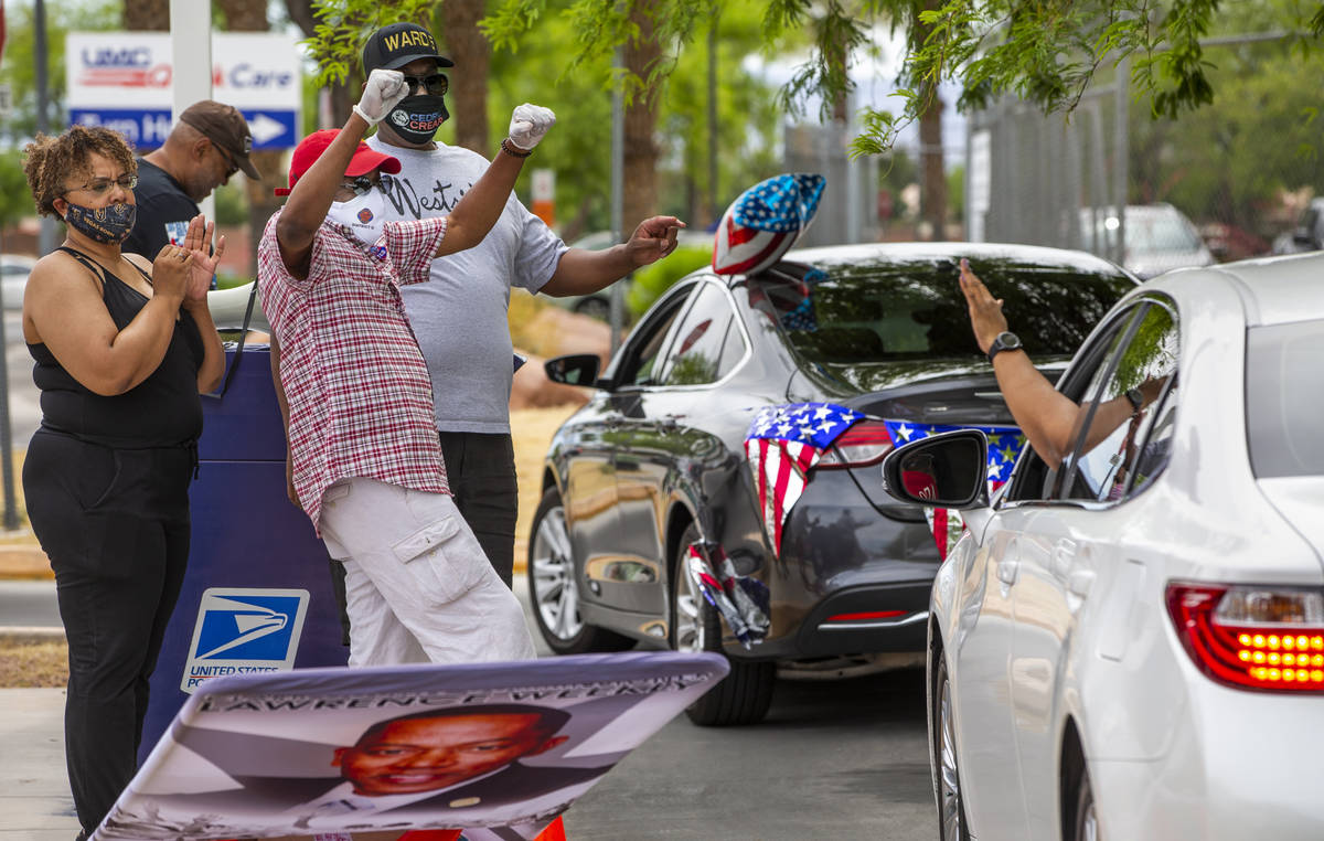 Clark County Commission Vice Chairman Lawrence Weekly, center, celebrates with drivers while jo ...