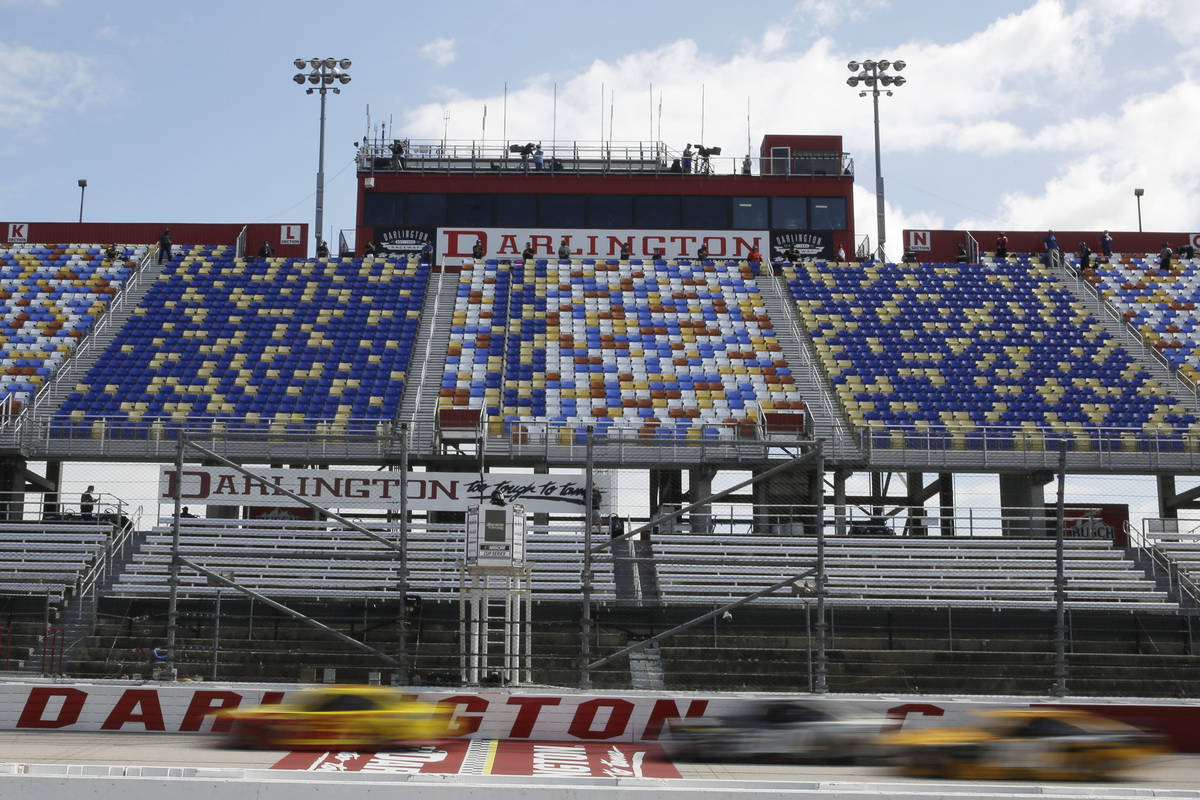 Cars pass by empty seats during the NASCAR Cup Series auto race Sunday, May 17, 2020, in Darlin ...