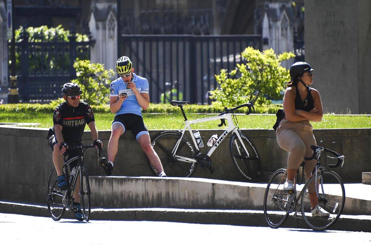 Cyclists wait at Parliament Square, in London, Monday, May 18, 2020. Large areas of London are ...