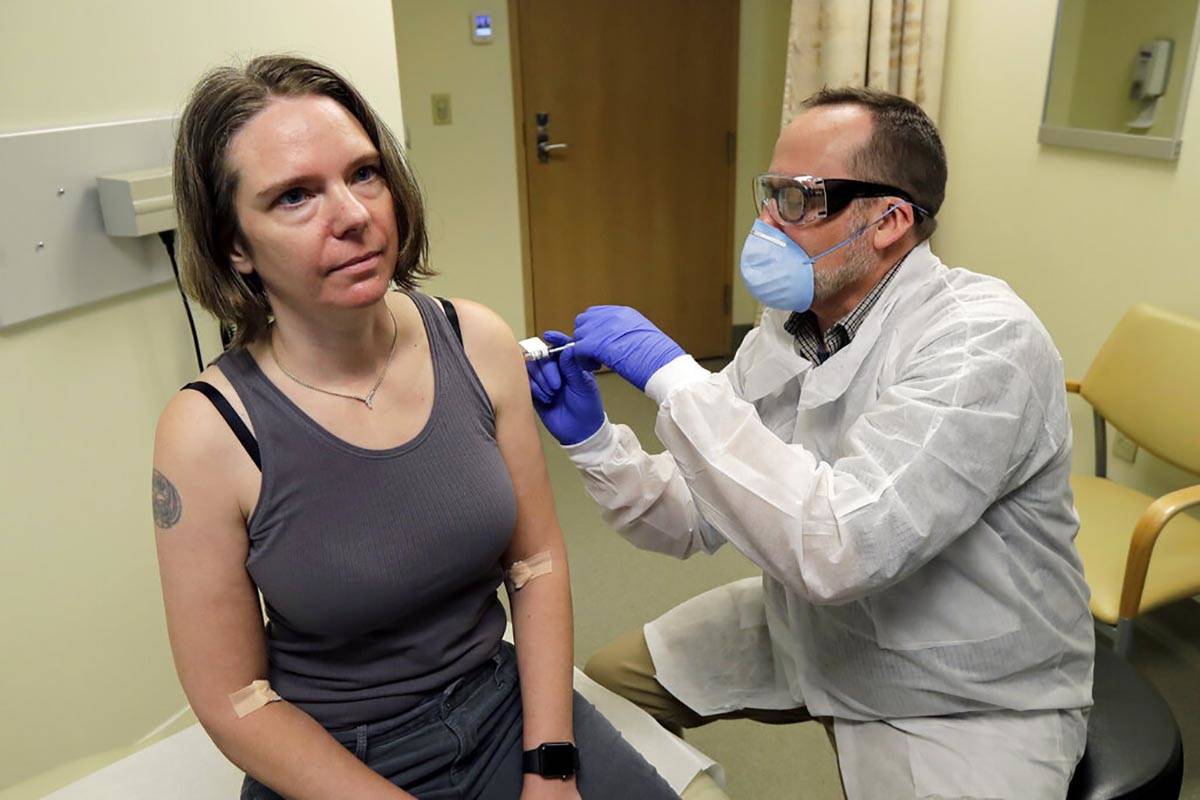 In this March 16, 2020, file photo, a pharmacist gives Jennifer Haller, left, the first shot in ...