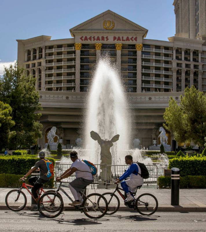 Cyclists look on to see the main Caesars Palace fountain area is back in operation on Monday, M ...