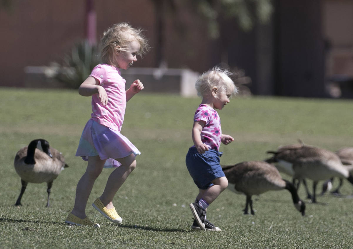 Evelyn McClellan, left, 3, and her 18-month-old sister, Emery, play at Cornerstone Park on Tues ...