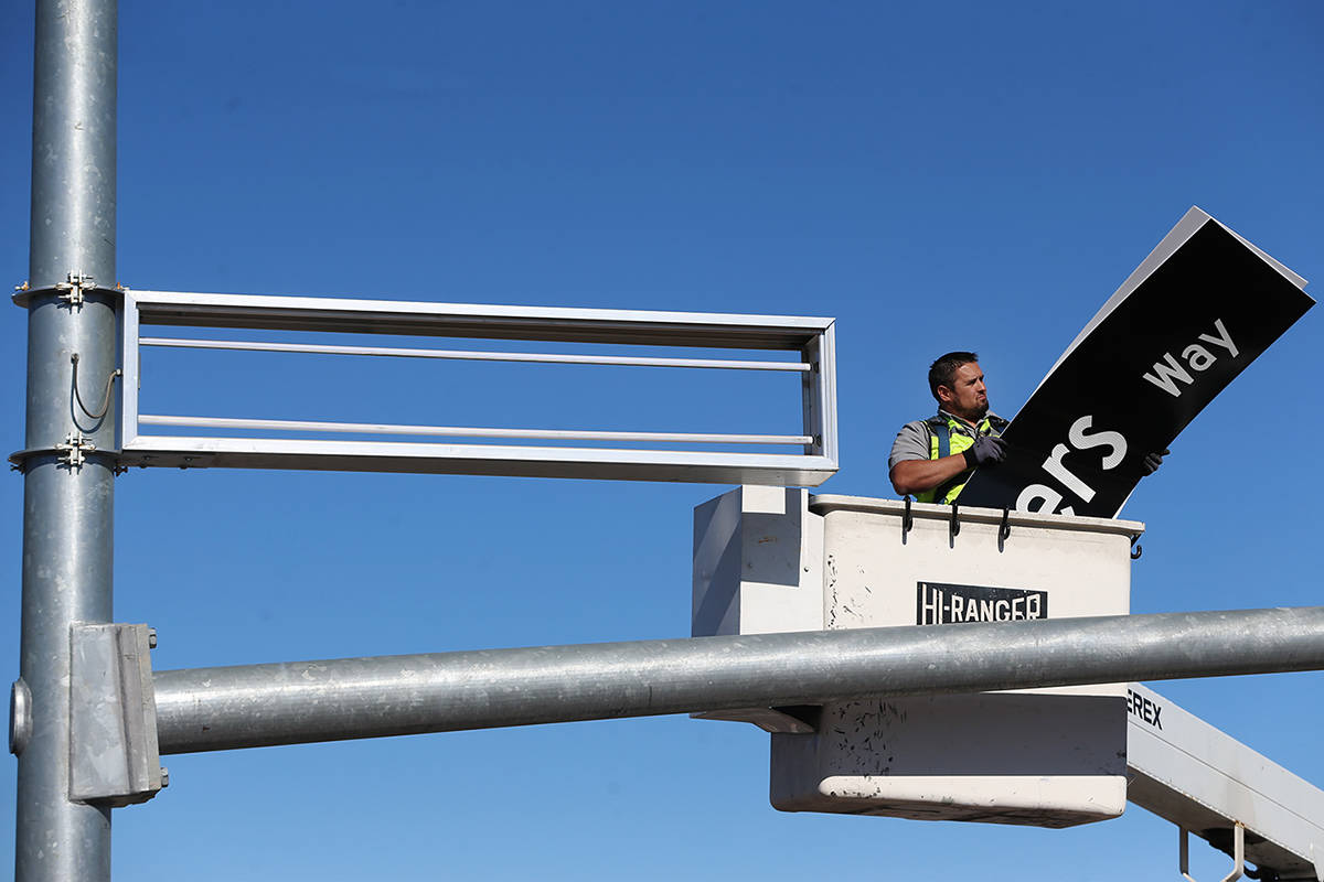 Adam Anderson, a driver traffic signal technician for the city of Henderson, installs a Raiders ...