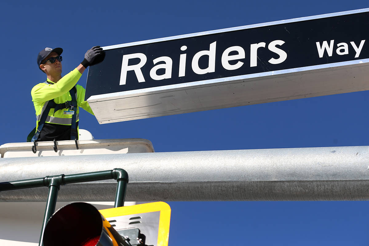 Justin Buhl, a traffic signal technician for the city of Henderson, installs a Raiders Way stre ...