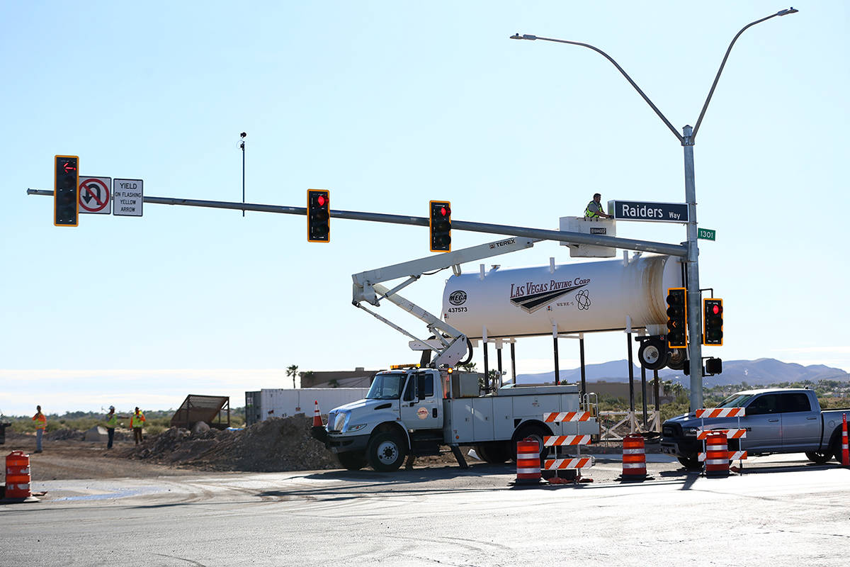 Adam Anderson, driver traffic signal technician for the city of Henderson, installs a Raiders W ...