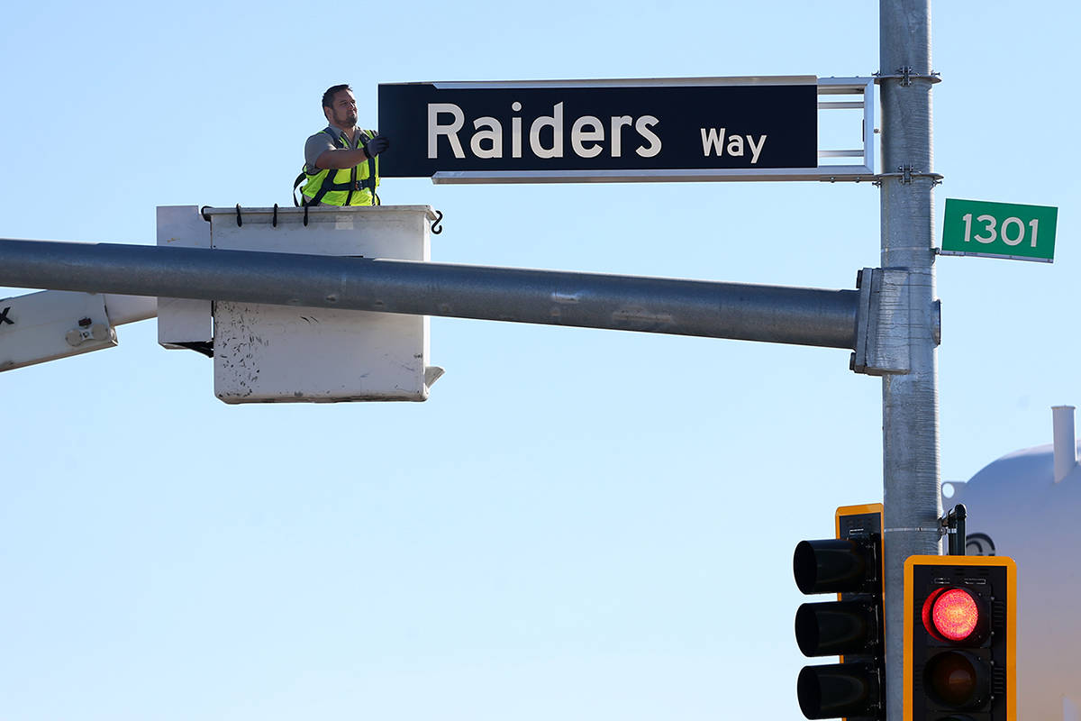 Adam Anderson, driver traffic signal technician for the city of Henderson, installs a Raiders W ...