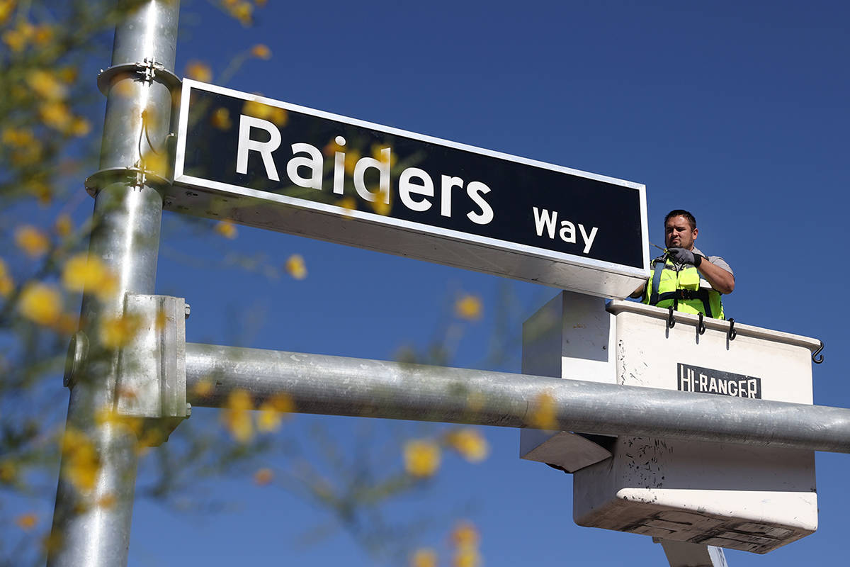 Adam Anderson, driver traffic signal technician for the city of Henderson, installs a Raiders W ...