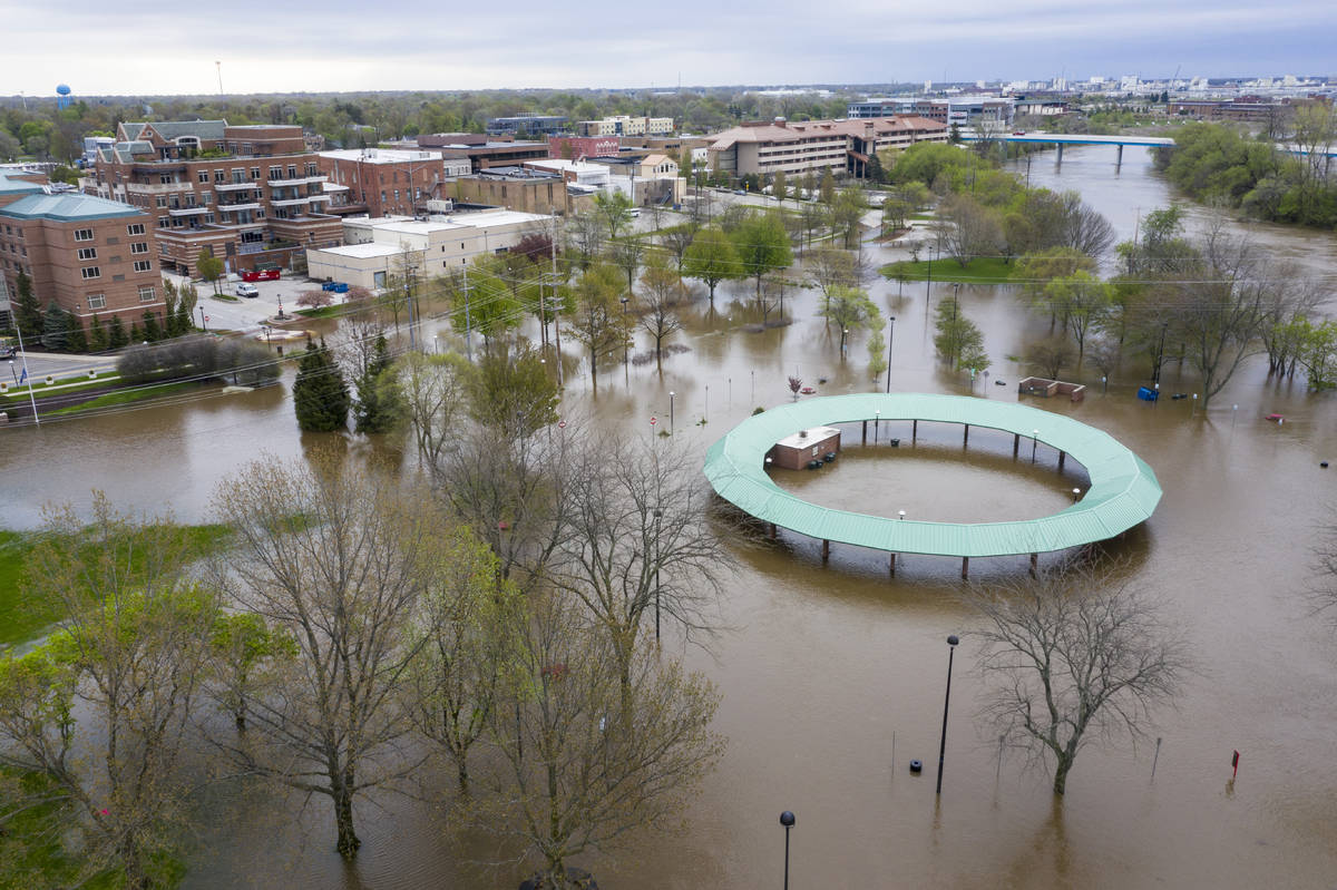 Water floods the Midland Area Farmers Market and the bridge along the Tittabawassee River in Mi ...