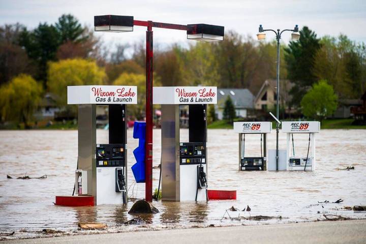 Floodwater surrounds gas pumps at Wixom Lake Gas & Launch Tuesday, May 19, 2020, along the ...