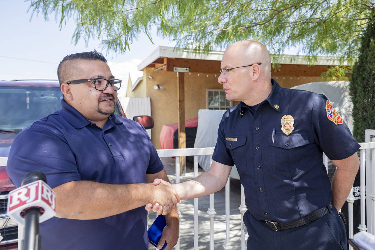 Jose Alvarado, left, is congratulated by North Las Vegas Fire Chief Joseph Calhoun on Wednesday ...