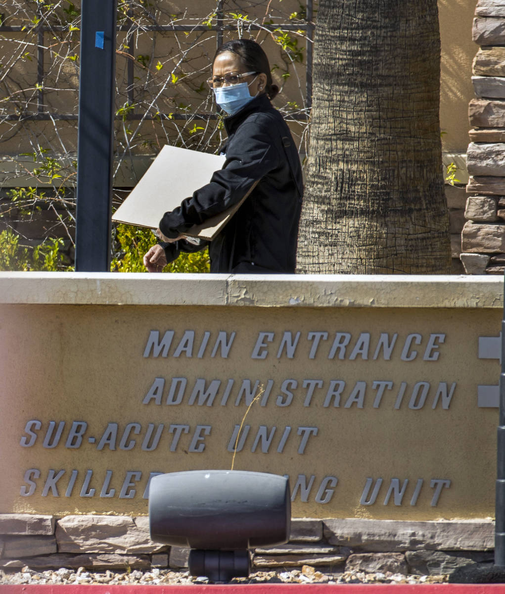 A woman walks outside of The Heights of Summerlin, which has had numerous deaths there due to C ...