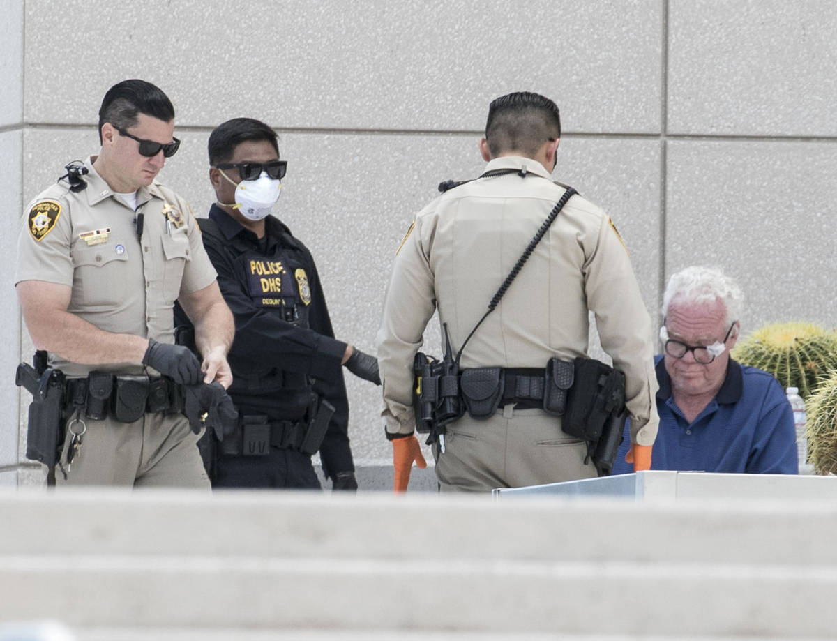 A man is detained as Las Vegas police investigate a report of a suspicious device outside the L ...
