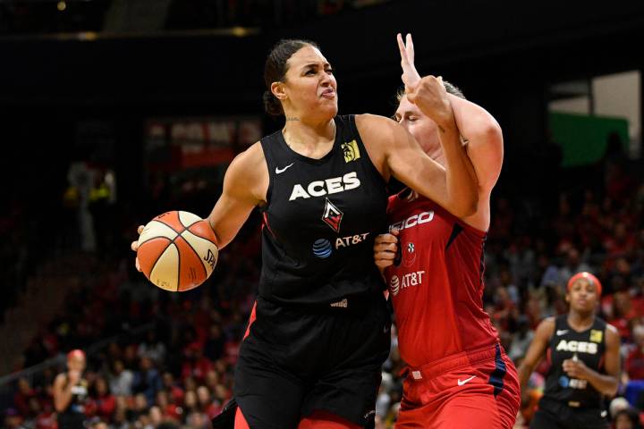 Las Vegas Aces center Liz Cambage, left, drives to the basket against Washington Mystics center ...