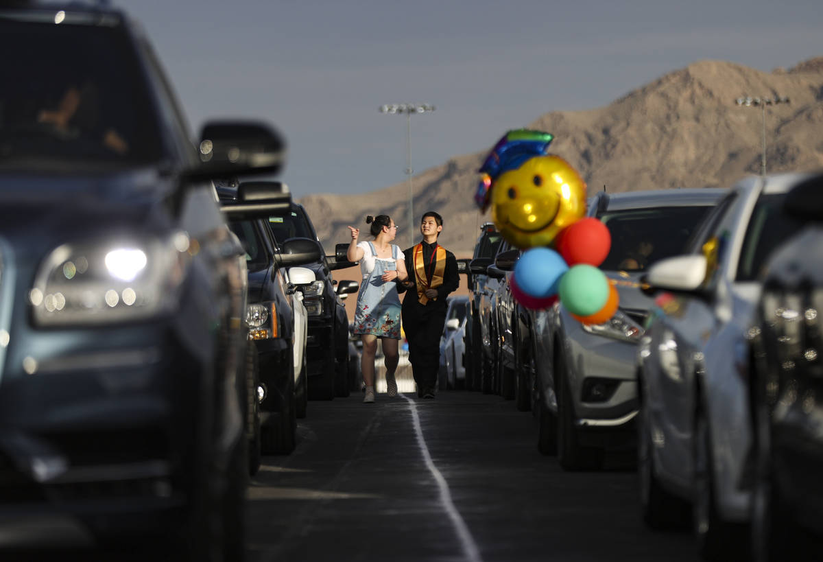 A Faith Lutheran High School student walks between cars before the start of a graduation ceremo ...