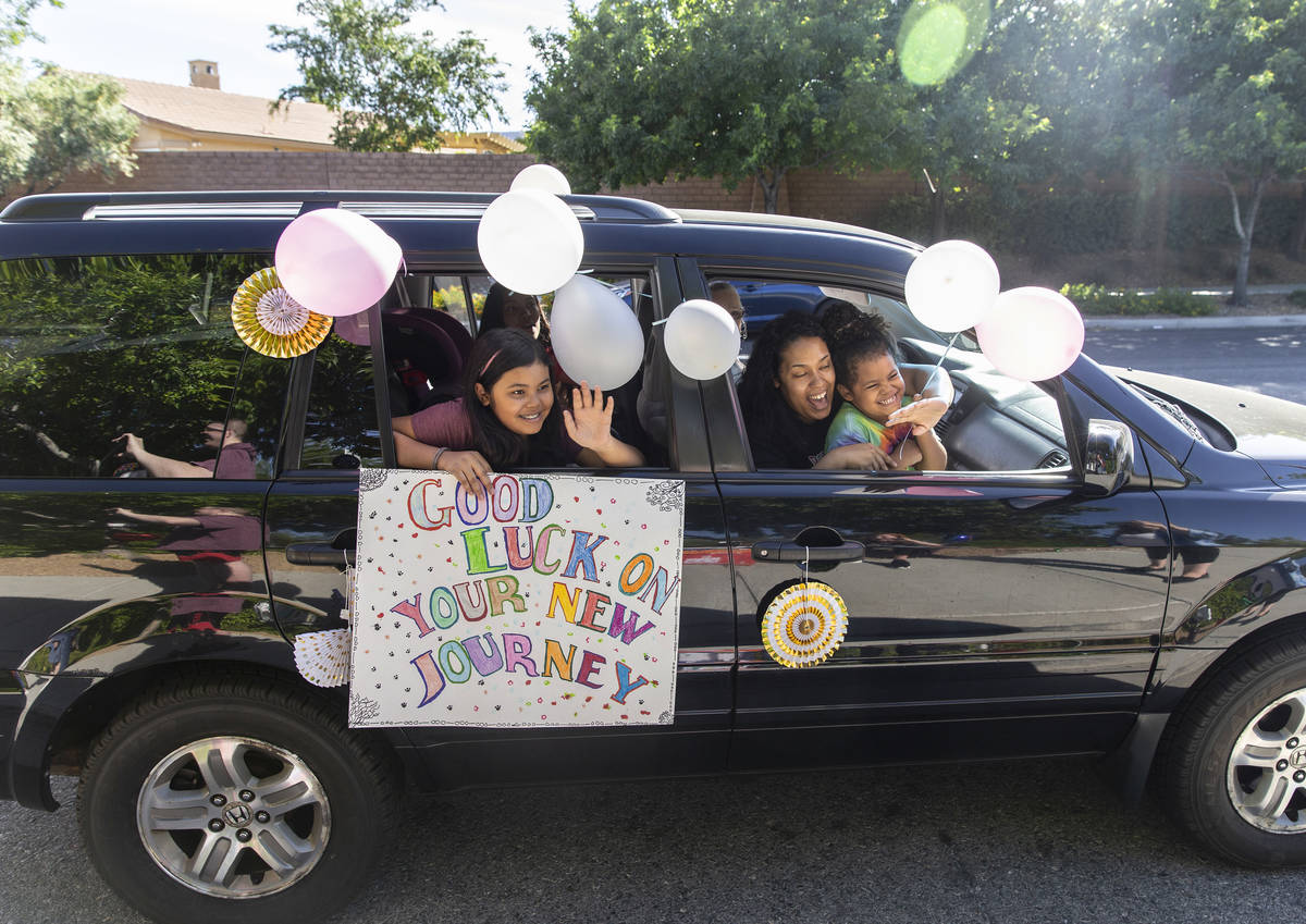 Signs sending well wishes can be seen from a line of cars during a “drive-by” re ...