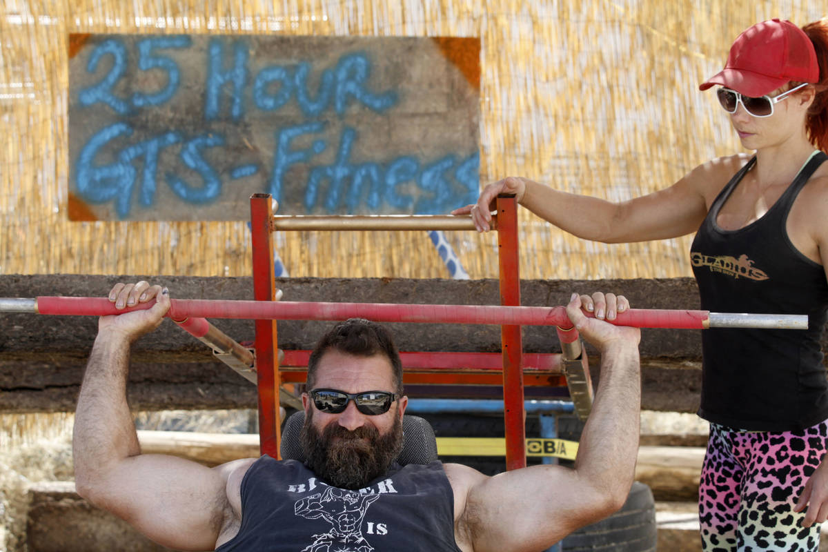 Gladius The Show co-owner Erik Martonovich uses homemade gym equipment to work out as his wife ...