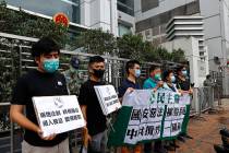 Members of the Democratic Party hold banner and placards during a protest in front of the Chine ...