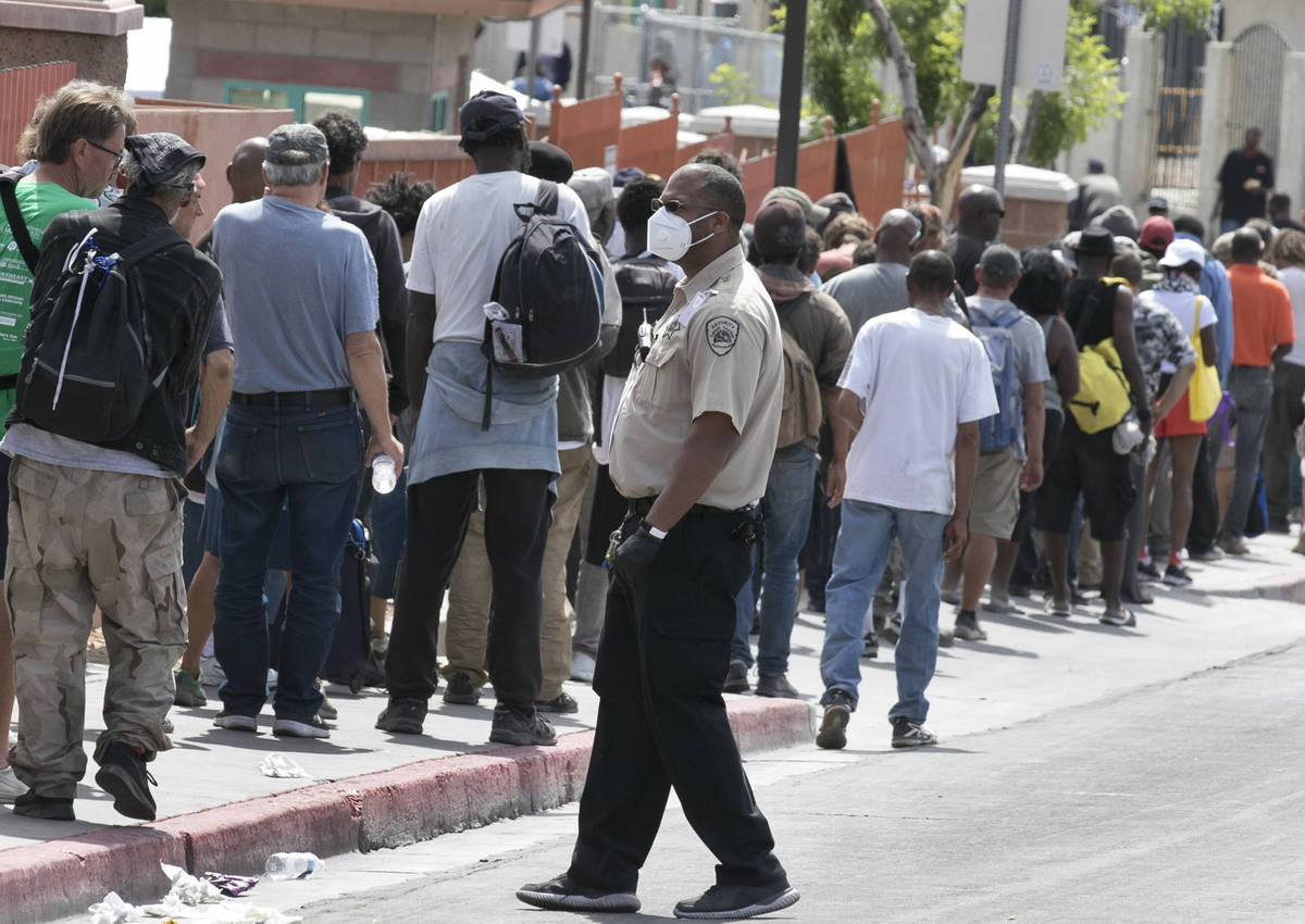 Homeless and needy people line up to receive food outside Catholic Charities on Thursday, May 1 ...