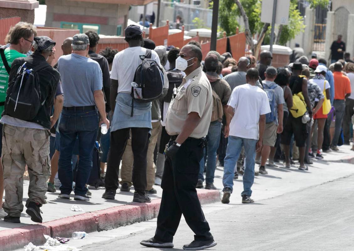 Homeless and needy people line up to receive food outside Catholic Charities on Thursday, May 1 ...