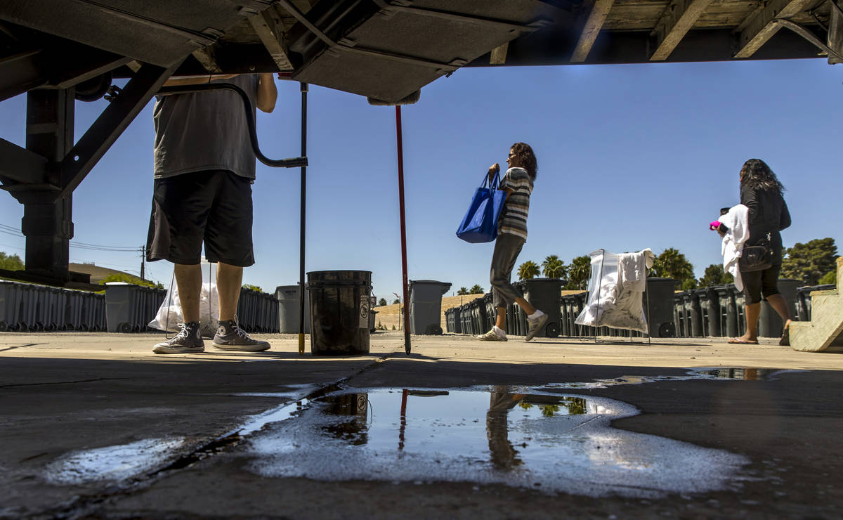 Clients finish up their washing as the Fresh Start Mobile Showers truck returns to The Courtyar ...