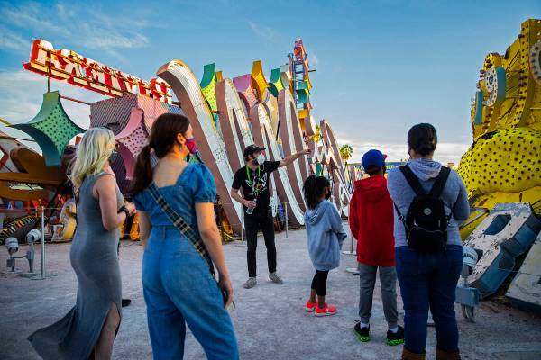 Interpreter Tyler Tingey, middle, leads a tour at The Neon Museum on Friday, May 22, 2020, in L ...