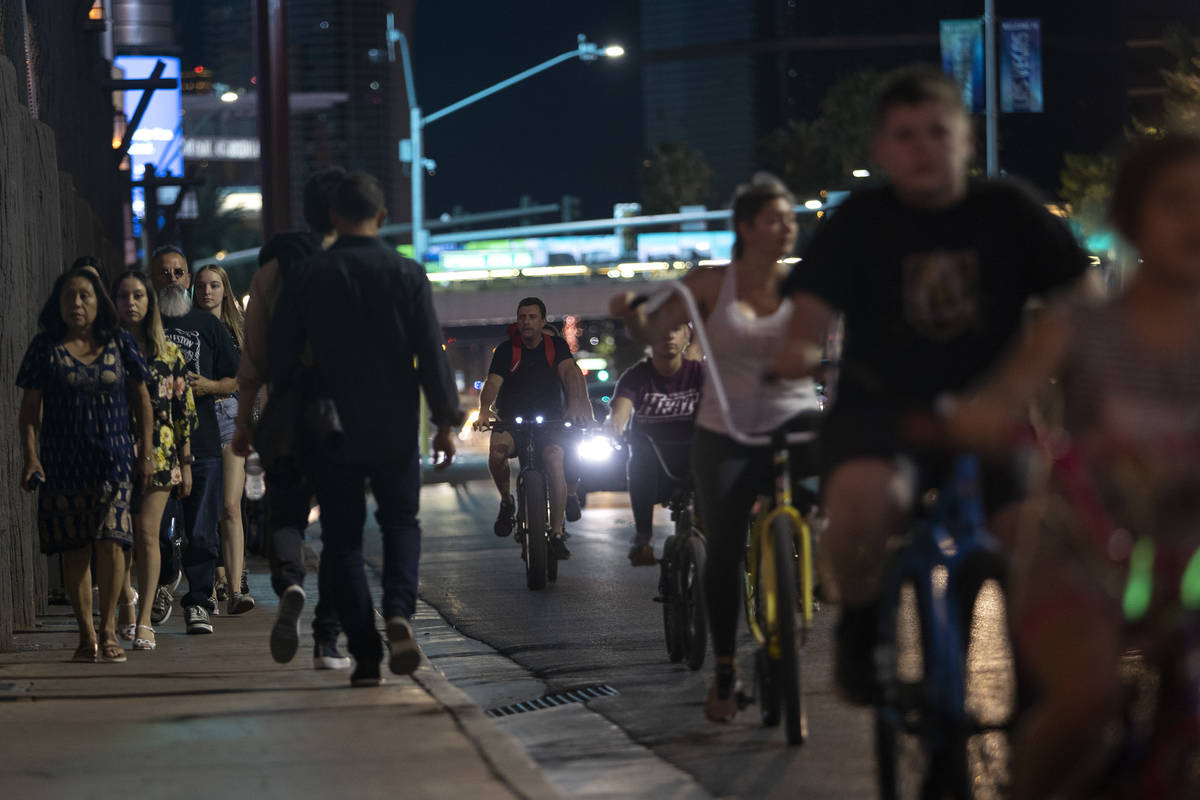 Bikers pass people walking on the sidewalk down Las Vegas Boulevard during Memorial Day weekend ...