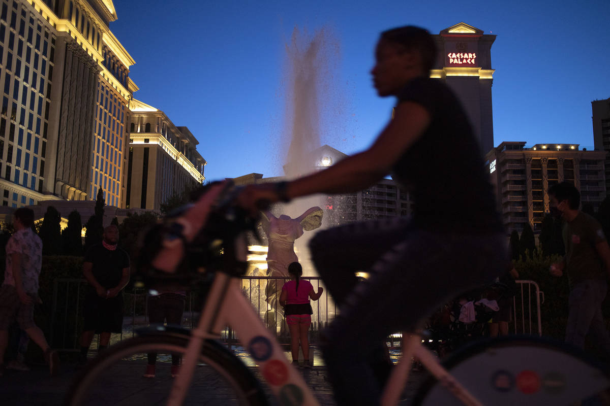 A biker passes the fountains at Caesars Palace on the Strip during Memorial Day weekend on Satu ...