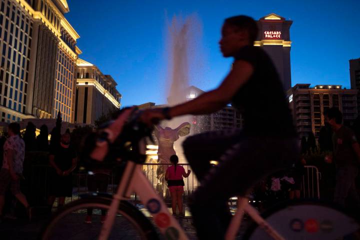 A biker passes the fountains at Caesars Palace on the Strip during Memorial Day weekend on Satu ...