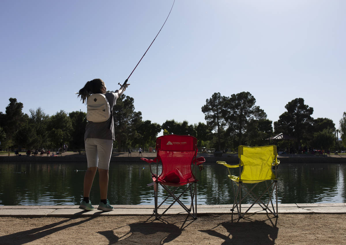 A girl casts her fishing pole into the pond during Memorial Day weekend at Sunset Park on Satur ...