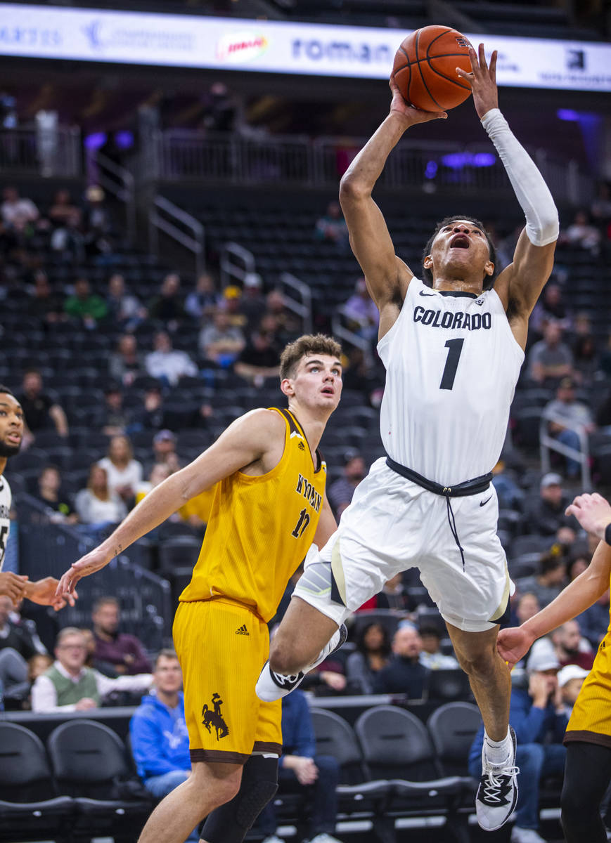Colorado guard Tyler Bey (1) elevates for a shot with Wyoming forward Hunter Thompson (10) duri ...