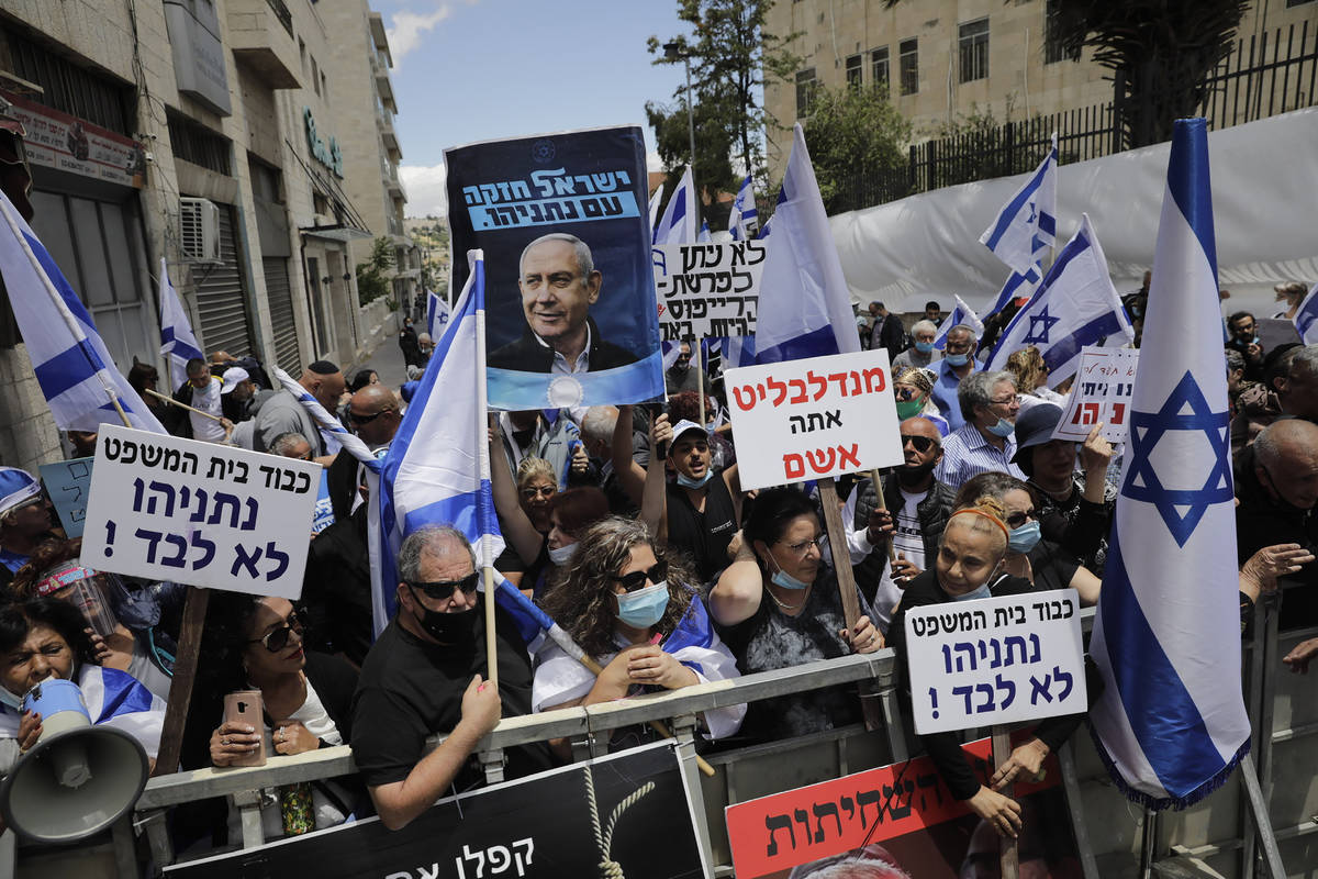 Israeli right wing activists hold flags and signs in support of Prime Minister Benjamin Netanya ...