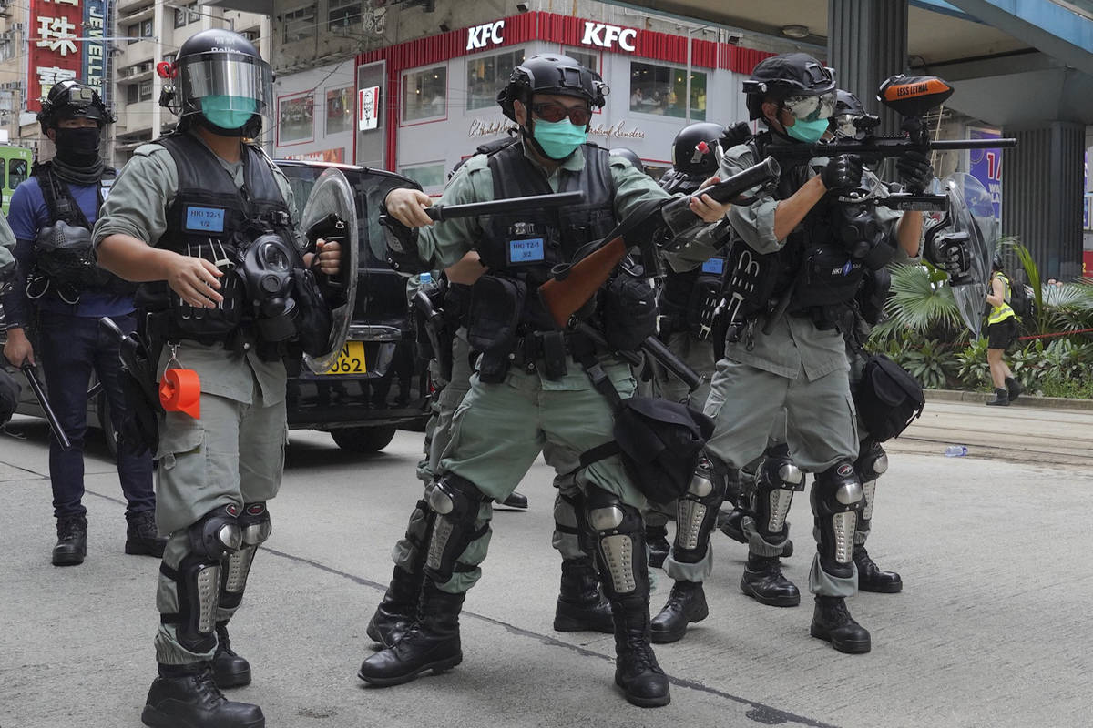 Hong Kong riot police fire tear gas as hundreds of protesters march along a downtown street dur ...