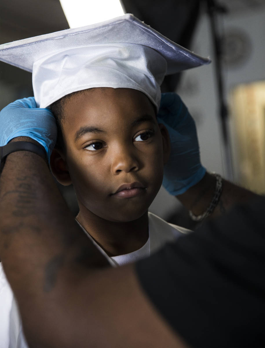 Dr. Dillard A. Scott adjusts the hat of Jourdyn Carson, 6, for his kindergarten graduation phot ...