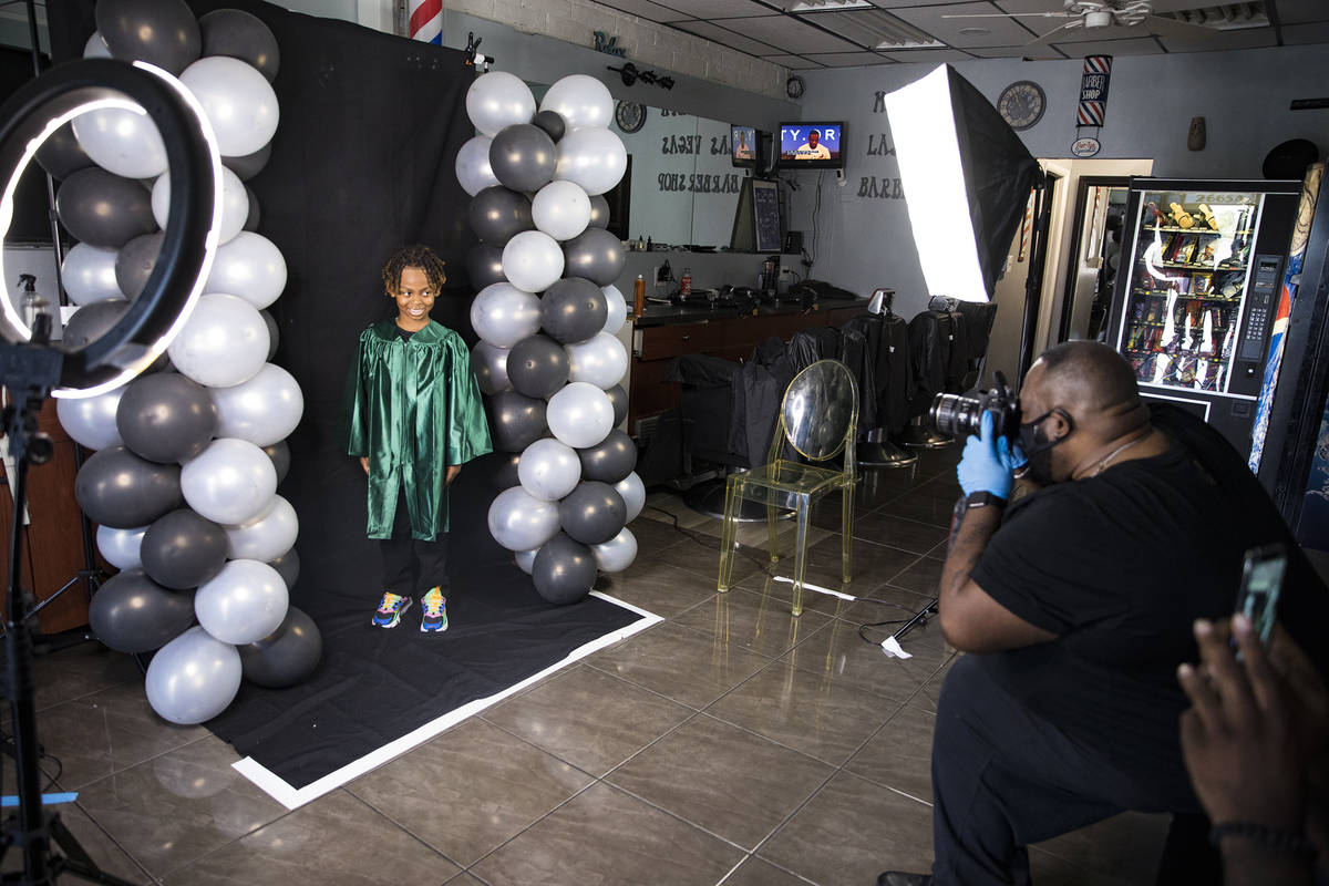 Dr. Dillard A. Scott takes a photo of Messiah Harris, 6, for his kindergarten graduation at Mr. ...