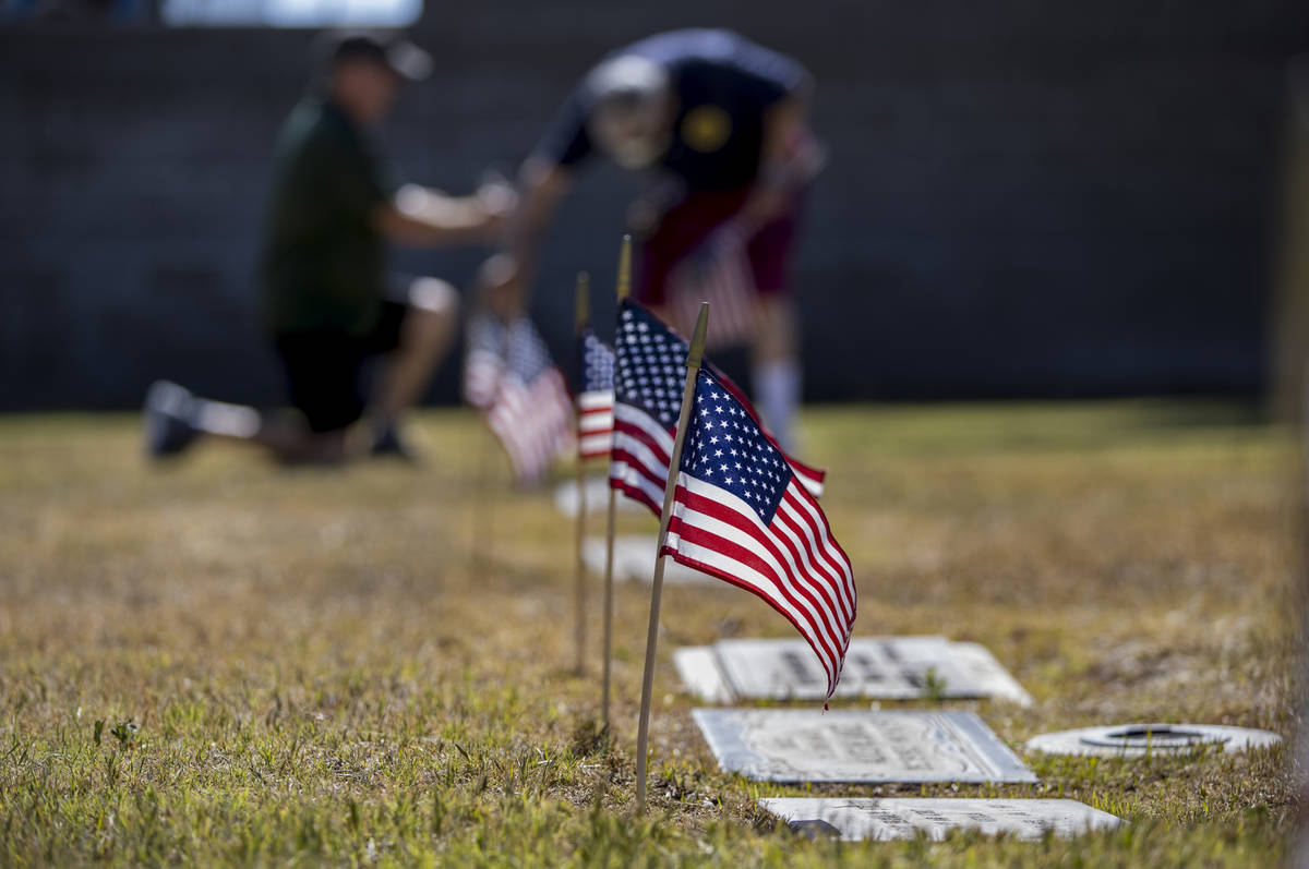 Frank Friedlander, left, and father Mort team up to plant American flags on veteran's graves in ...