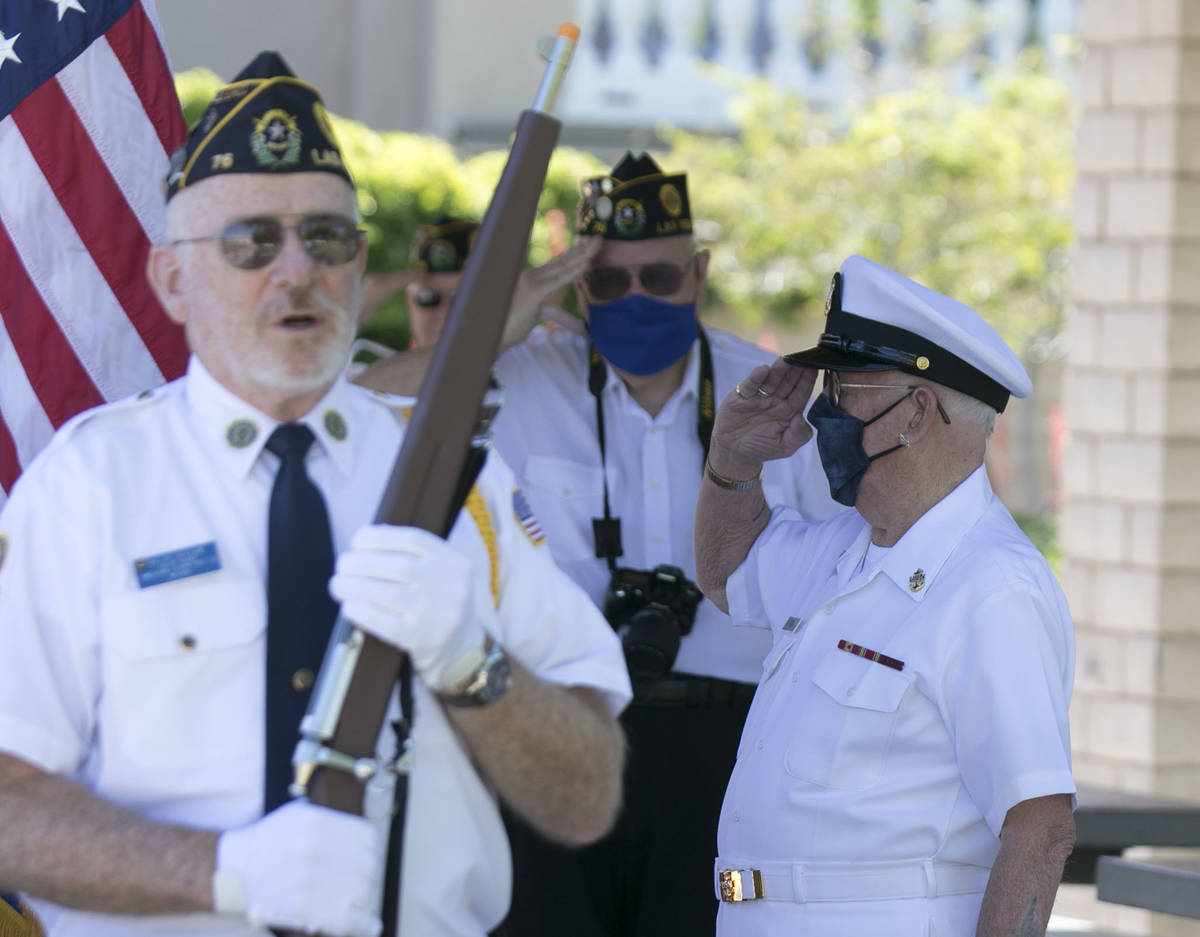 World War II U.S. Army Air Corps veteran Jack Ford, left, salutes as he prepares to lay a wreat ...