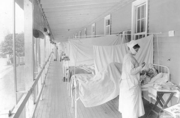 FILE - In this November 1918 photo made available by the Library of Congress, a nurse takes the ...