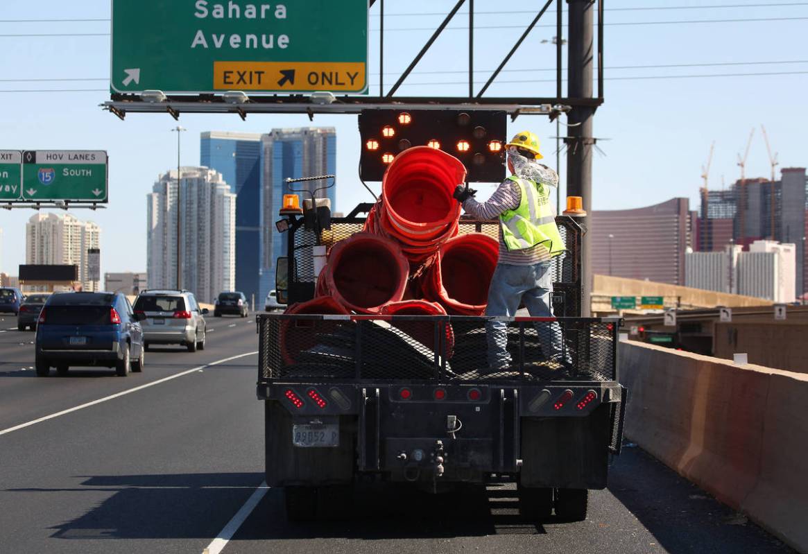 Crews work to remove orange safety barrels along Interstate 15 near the Sahara Avenue exit on M ...