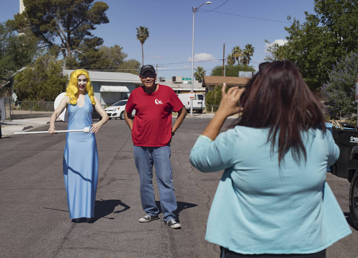 Victoria Hogan, dressed as the Blue Angel statue from the former Blue Angel Motel, takes a phot ...