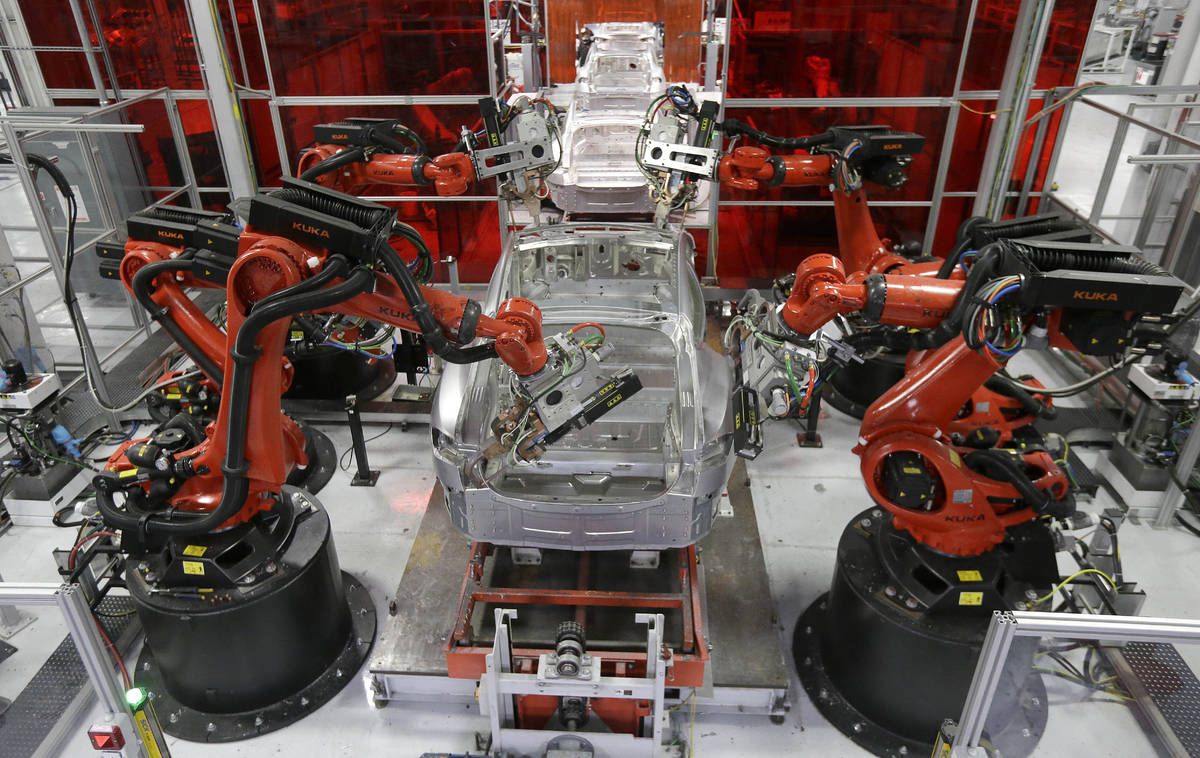 In this May 14, 2015, file photo, Kuka robots work on Tesla Model S cars in the Tesla factory i ...
