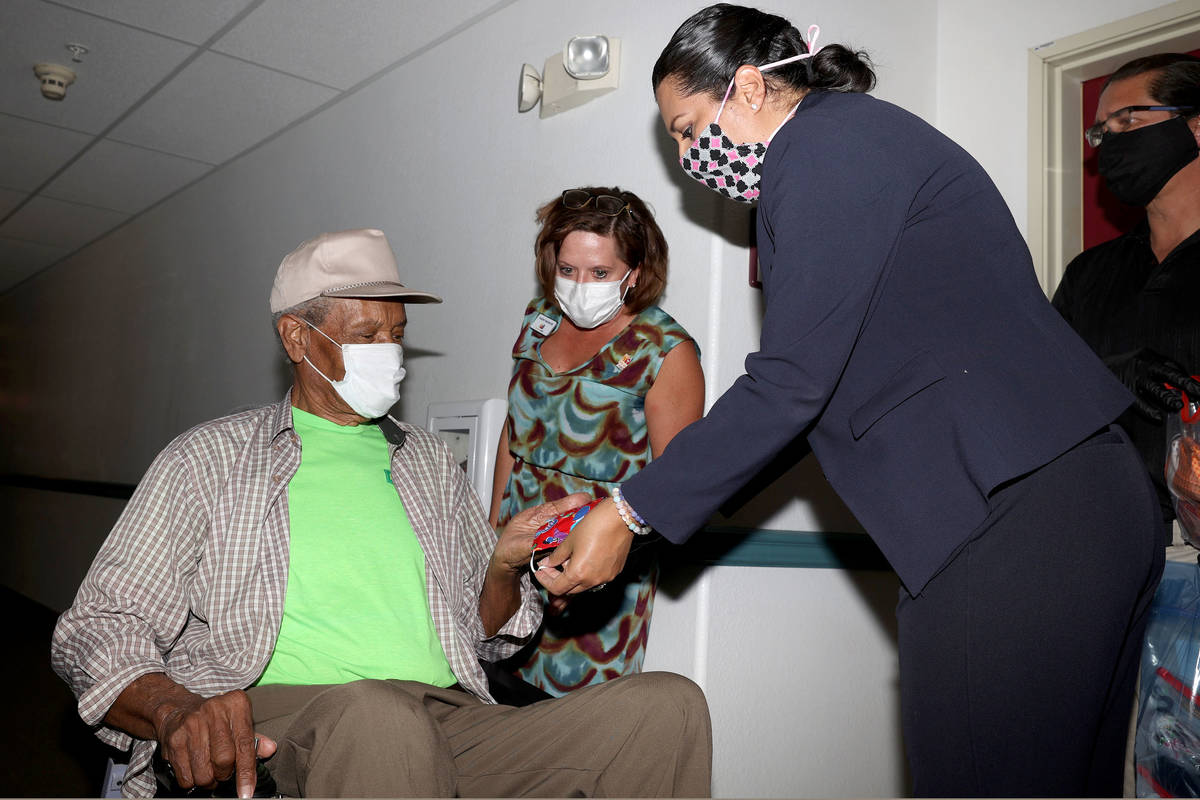 Louis Lewis, 83, receives a washable mask from Las Vegas Councilwoman Olivia Diaz at the Stewar ...