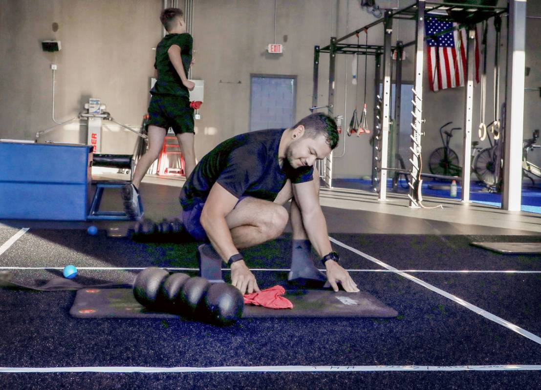 Brian Lee, member of The Gym Las Vegas, disinfects his mat, the first morning on the facility's ...