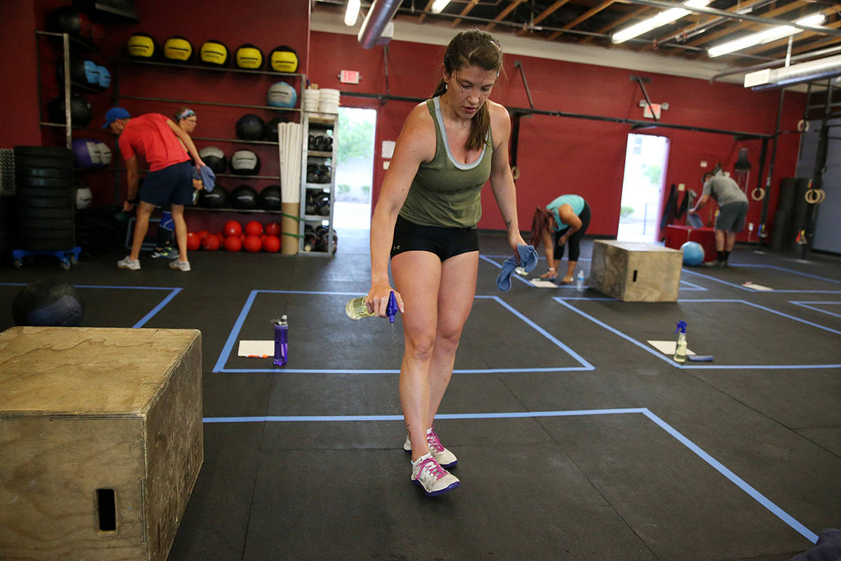 Kaydee Weida cleans her space after working out during a class at Crossfit Apollo in Las Vegas, ...