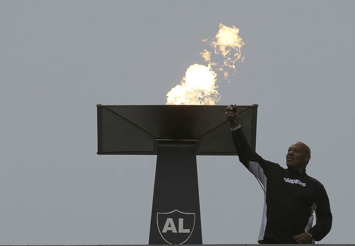 Former NFL football player Greg Townsend lights a ceremonial torch for former Oakland Raiders o ...